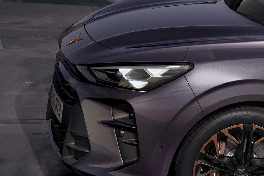 Vue avant du Cupra Terramar hybride rechargeable avec feux LED allumés